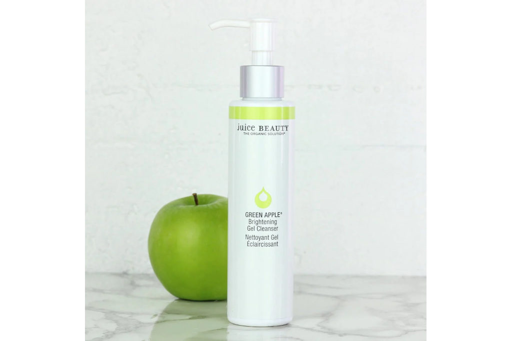 White cleanser bottle next to green apple