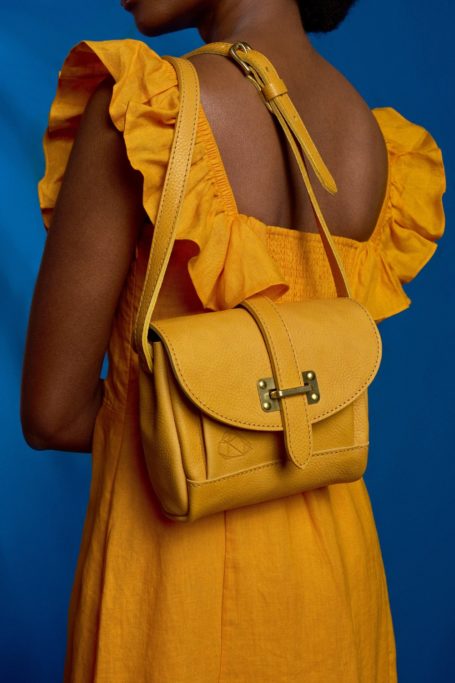 Woman in yellow sundress with matching yellow bag over shoulder