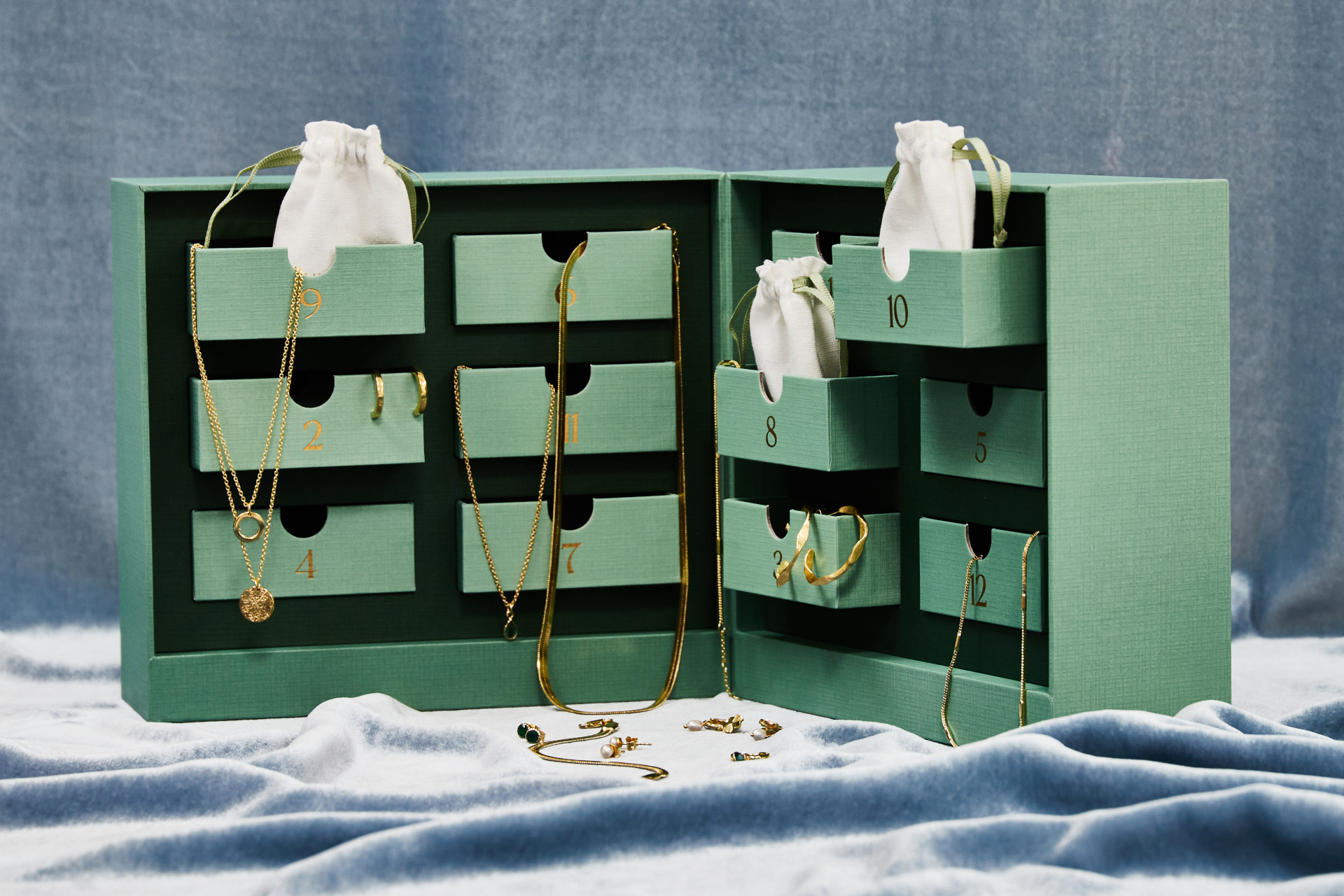 Green advent calendar with gold jewellery