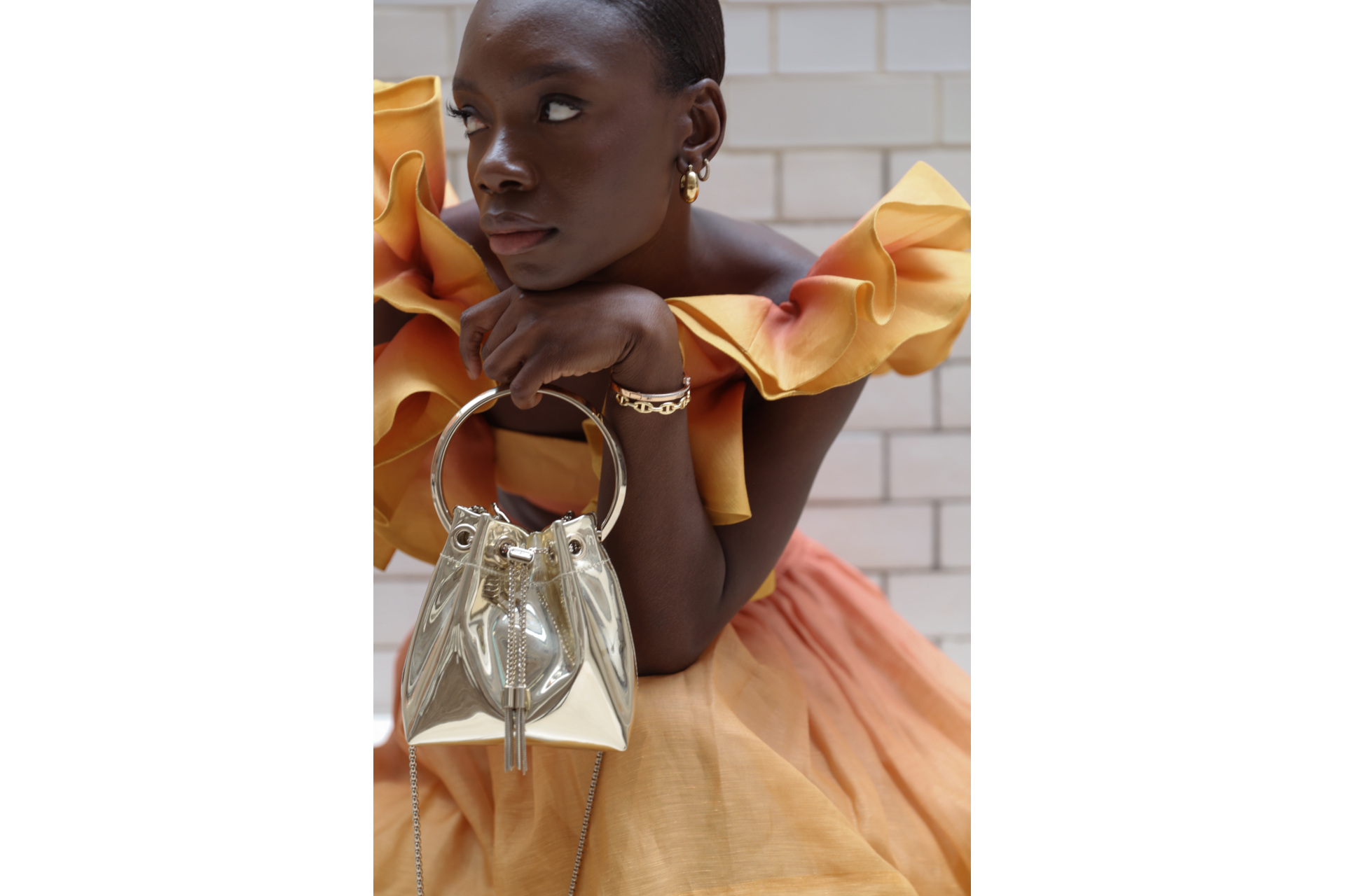 Woman in orange dress holding silver bag