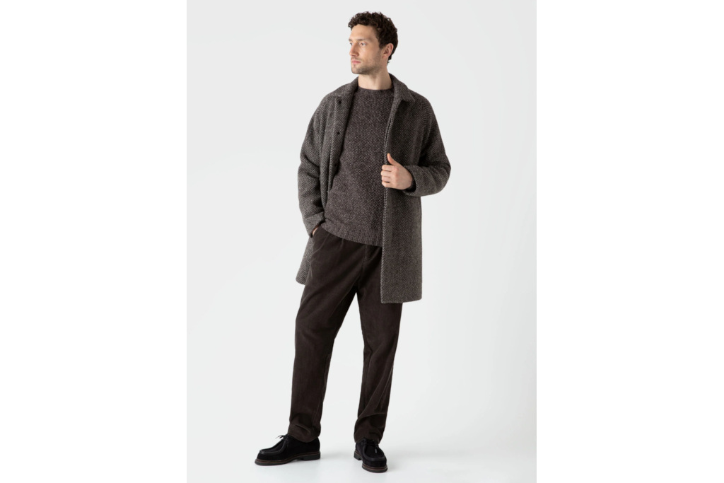 Man in grey top and jacket with black corduroy trousers