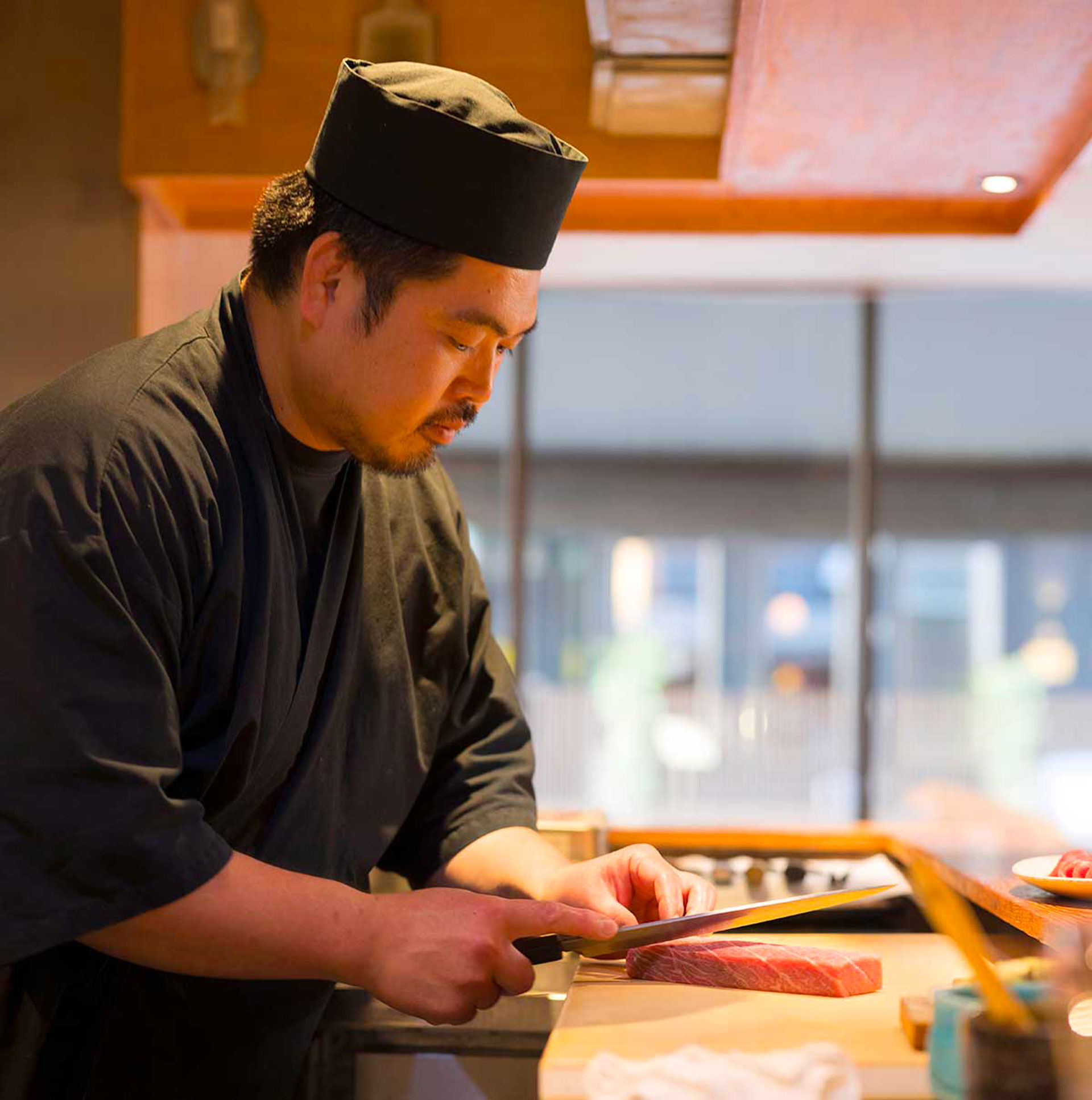 Chef cutting raw fish at Sushi Kyu