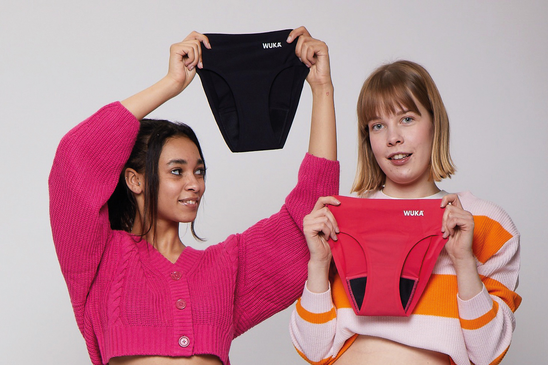 Two women holding up period pants from WUKA