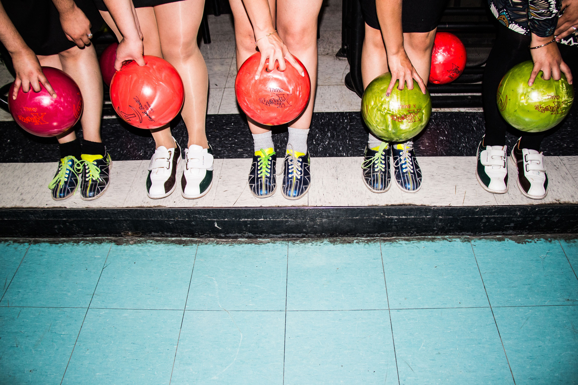 Five people holding bowling balls