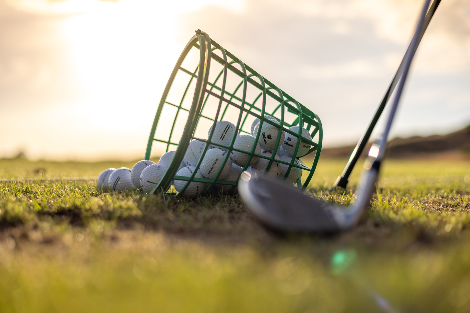 A bucket of golf balls at a driving range