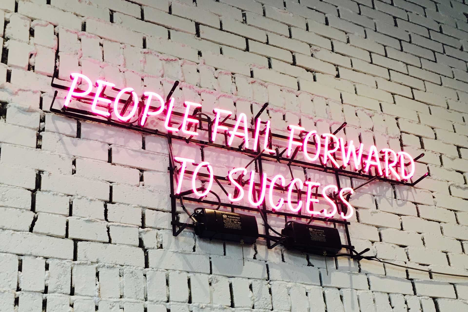 Neon lights reading people fail forward to success