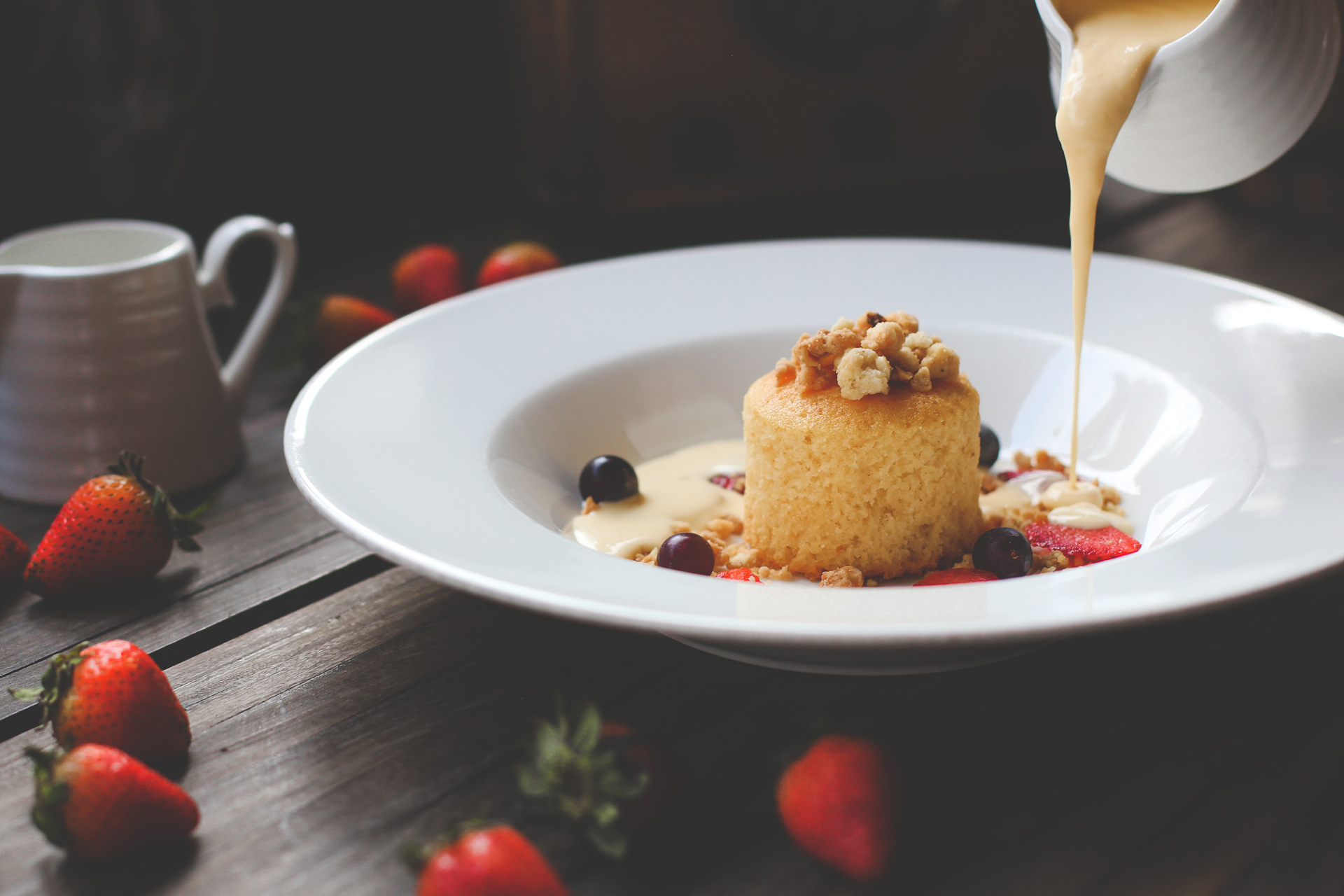 Pudding with custard being poured over