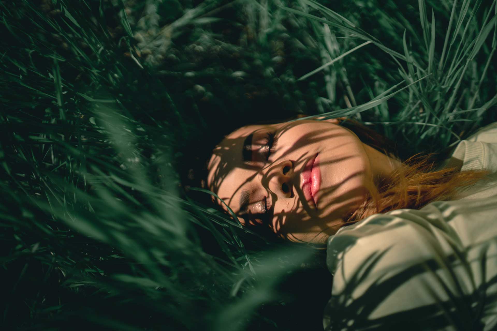 woman lying in grass with the sun on her skin