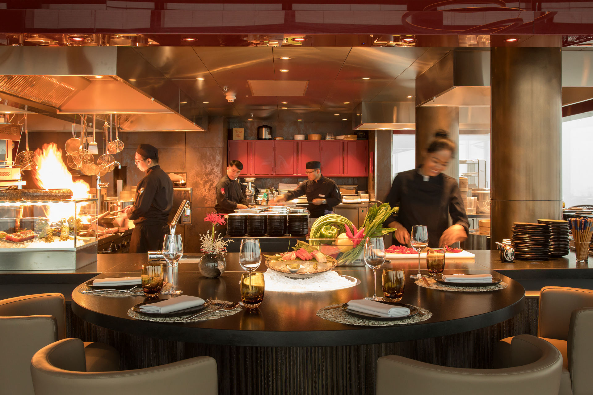 Open plan restaurant kitchen with set table in the foreground