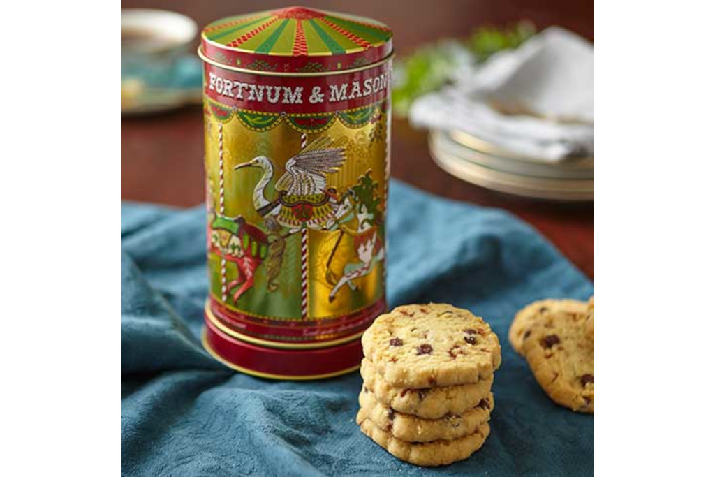 Gold tin next to biscuits, on blue cloth