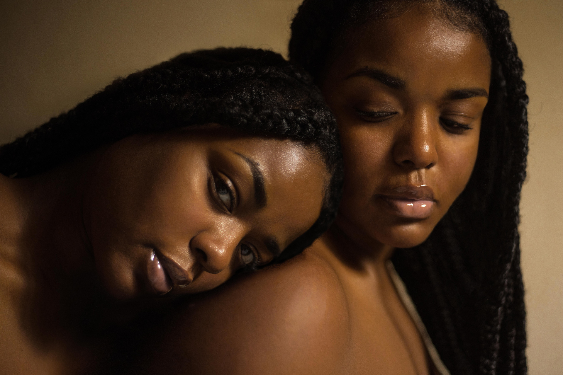 Two black women leaning on each other