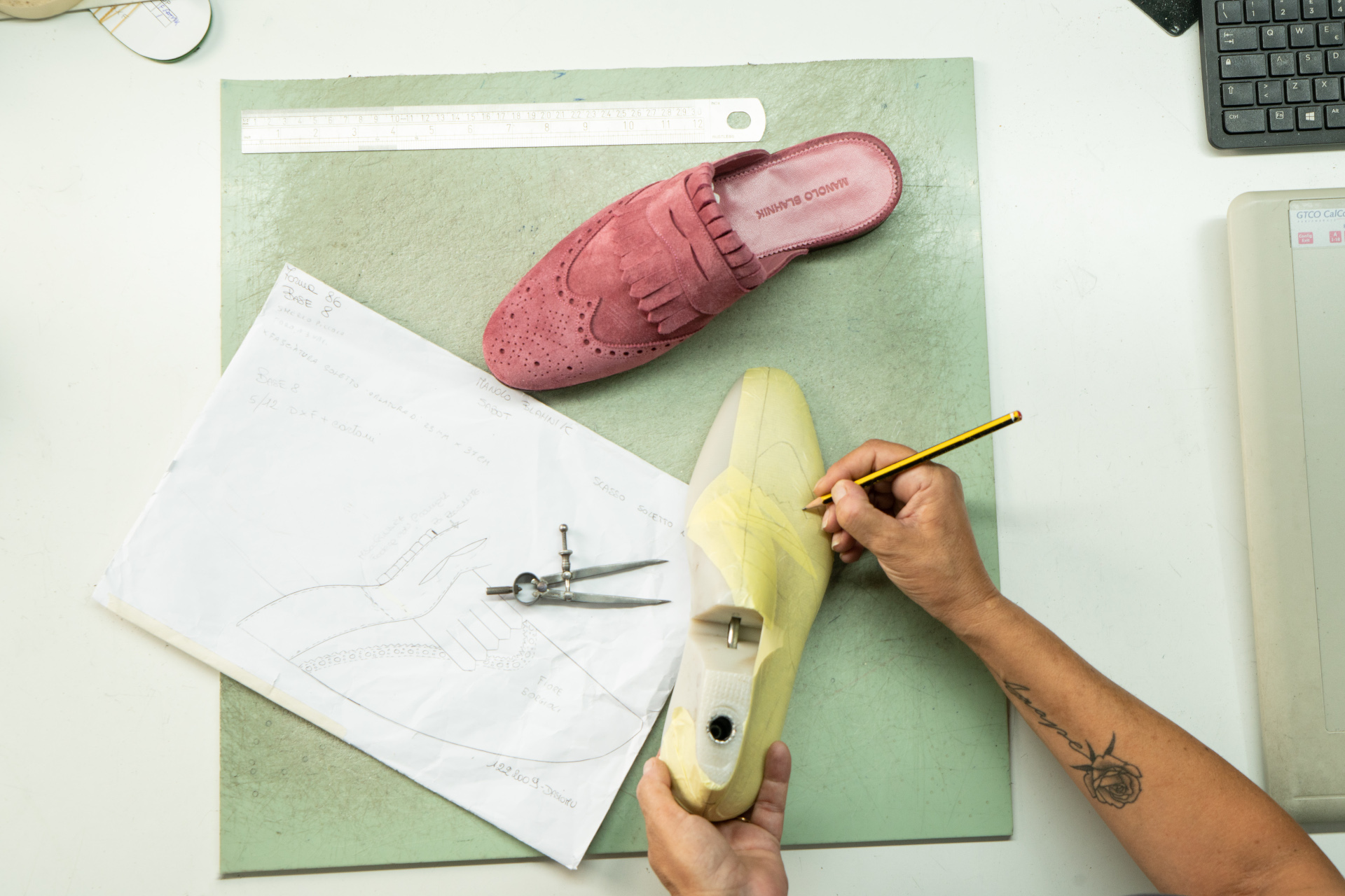 Overhead view of hands working on making a pink shoe