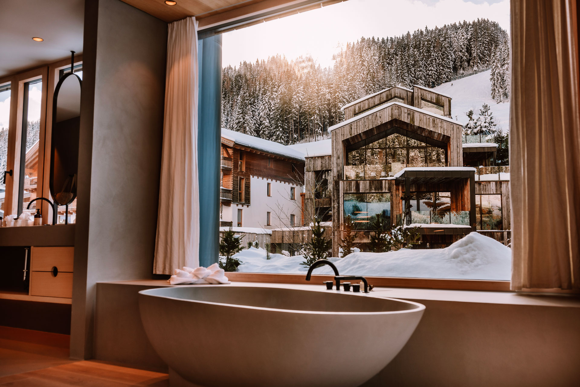 A freestanding bath by a window at Naturhotel Forsthofgut