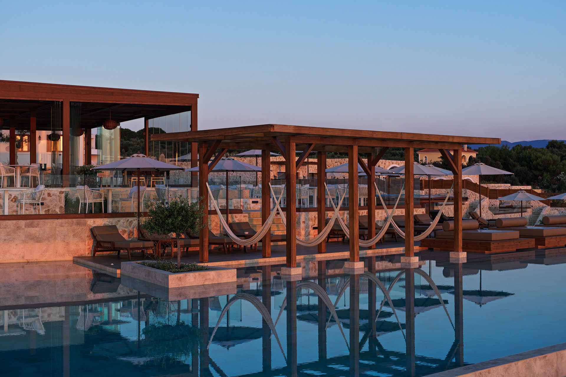 Pool with bar and sun loungers at sunset