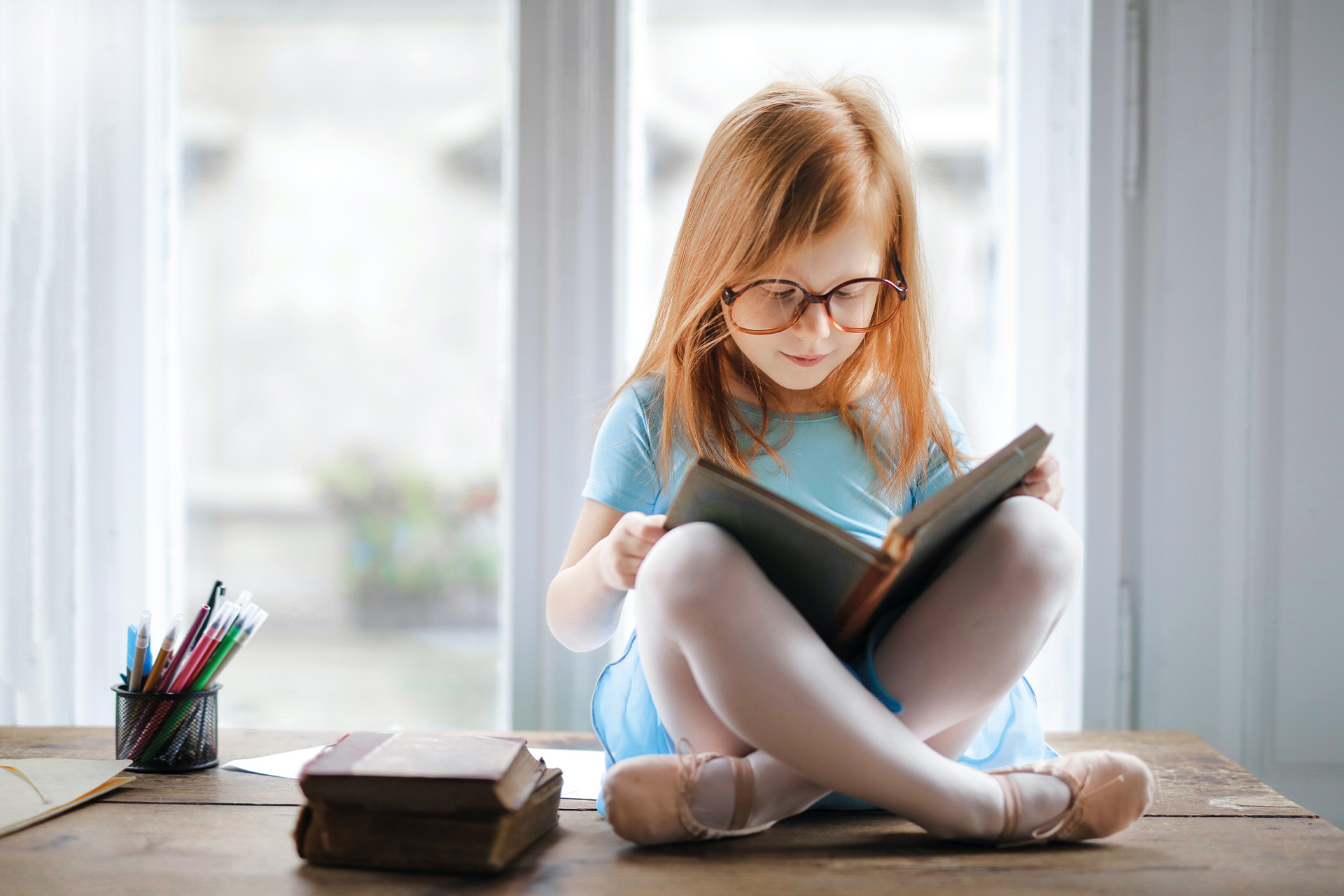 A young girl reading quietly on her own