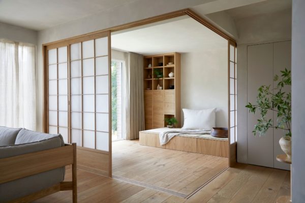 Japandi-style living room with wooden screen and mathcing window seat with bookshelf