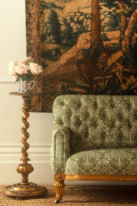Green sofa in front of tapestry | British textile designers