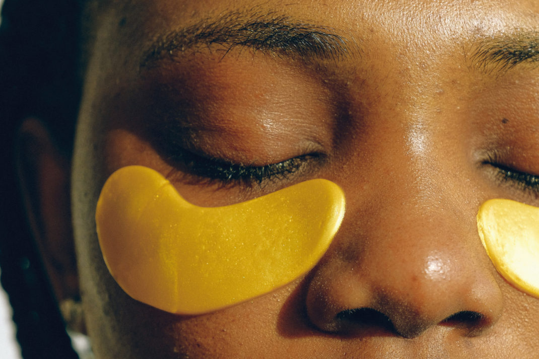 Close up of woman's face with gold under-eye mask