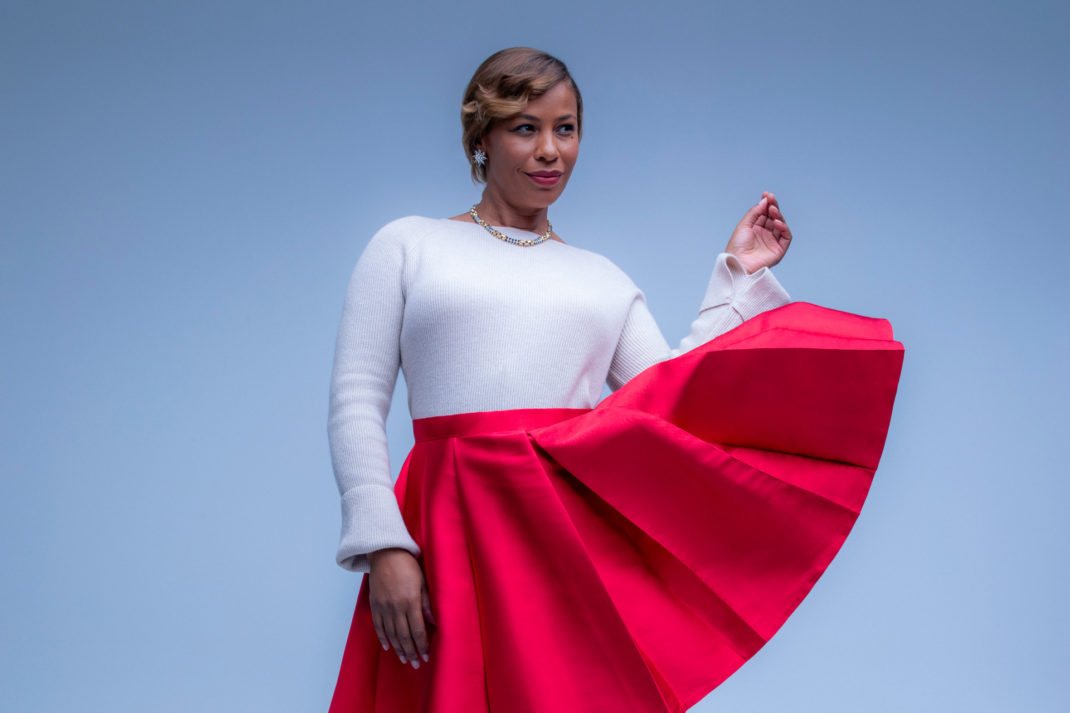 Woman in white top and red skirt on blue background