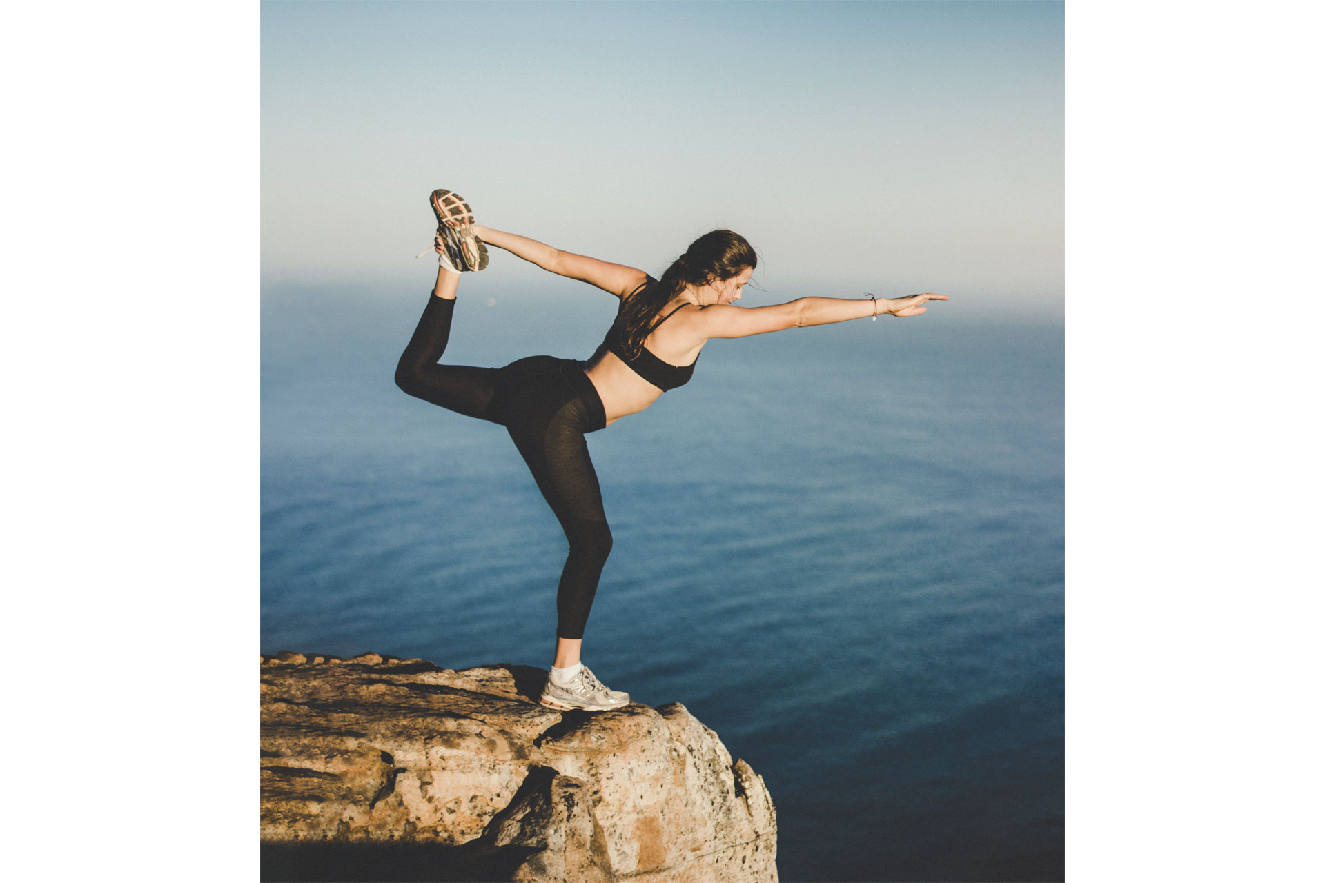 Lady doing yoga on a rock