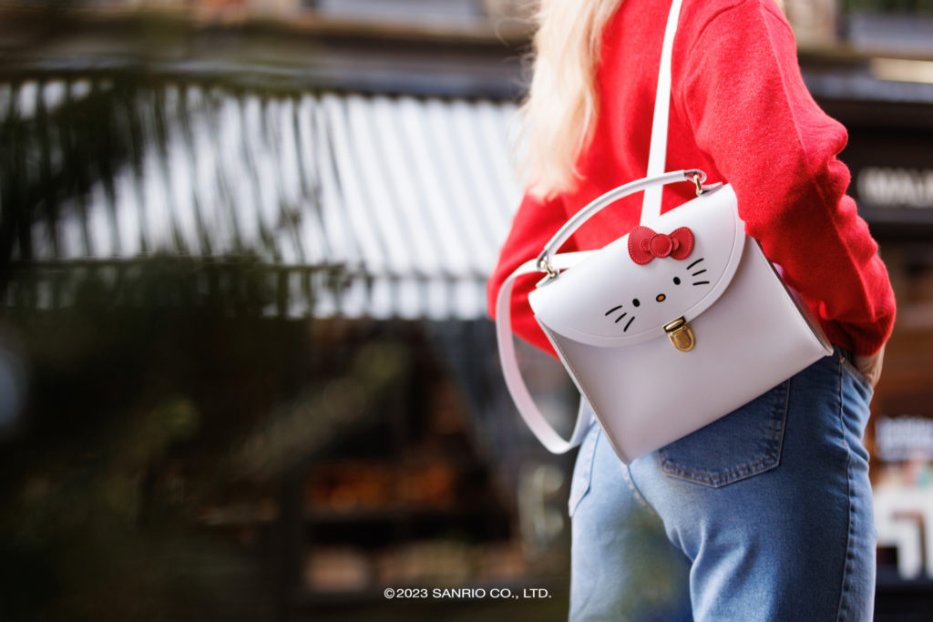 Woman holding Cambridge Satchel x Hello Kitty bag