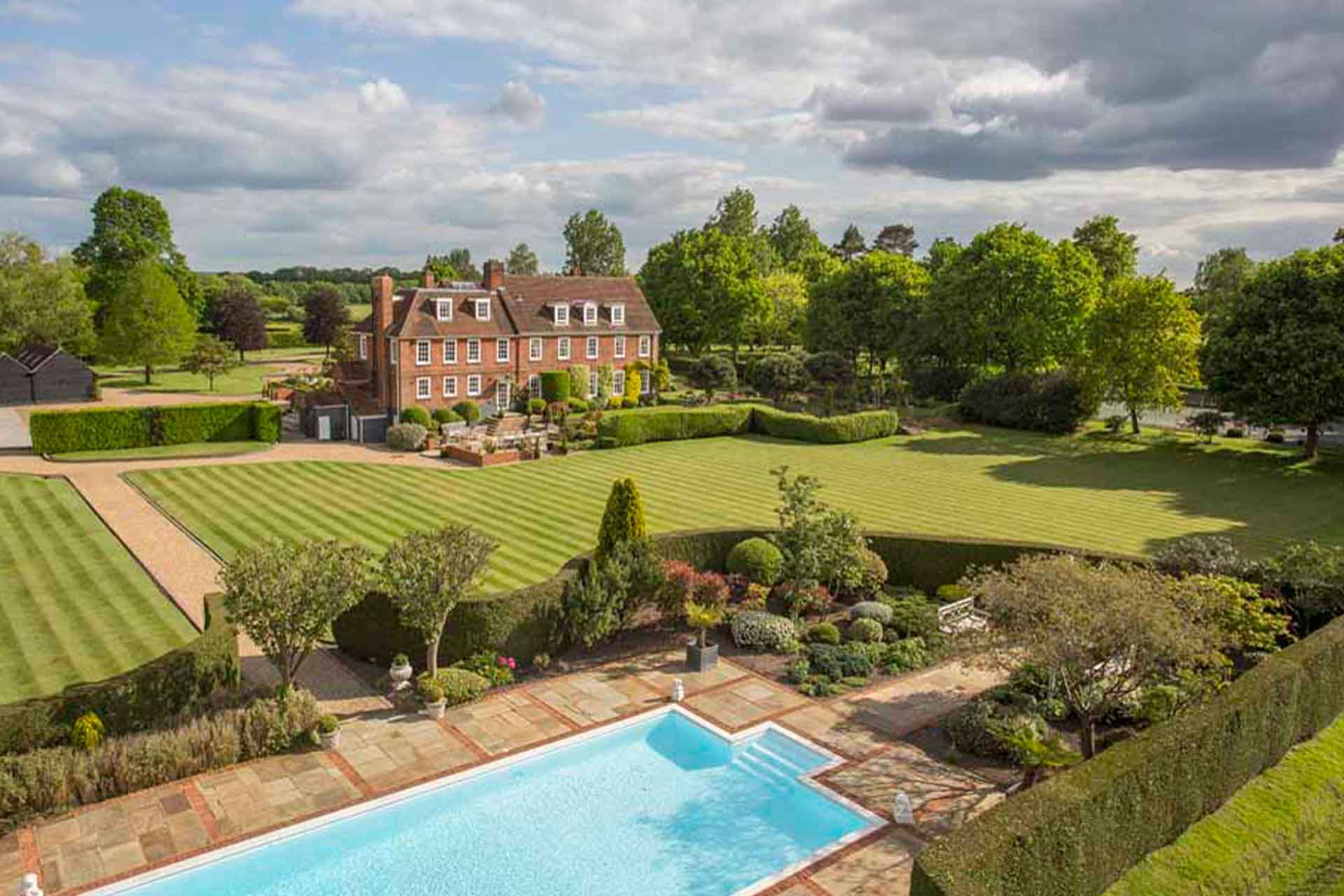 Aerial view of country home with expansive grounds and outdoor swimming pool