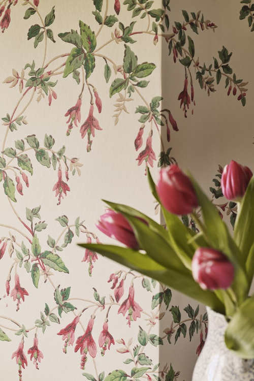Close up of vase of flowers in front of patterned wall