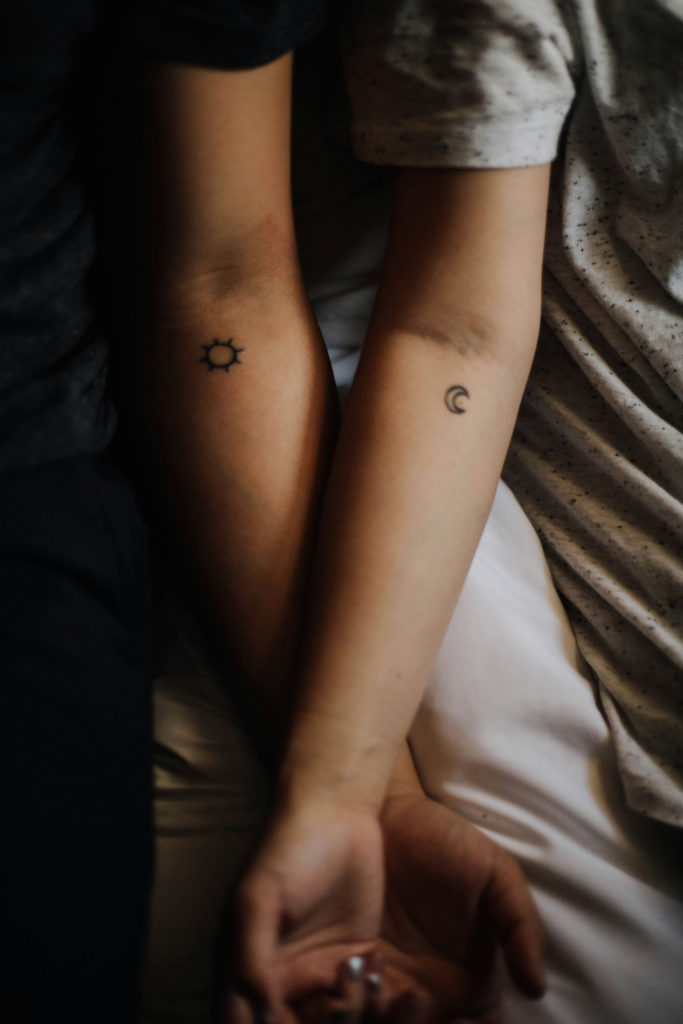 Two arms next to each other with small tattoos