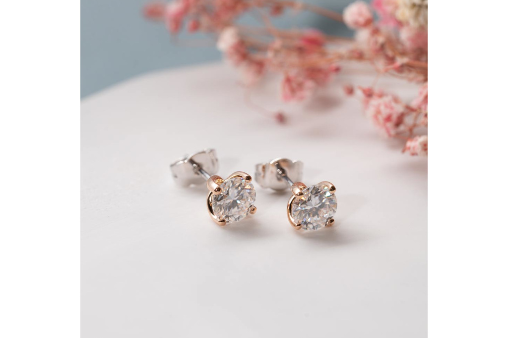 Stud earrings on table with pink flowers