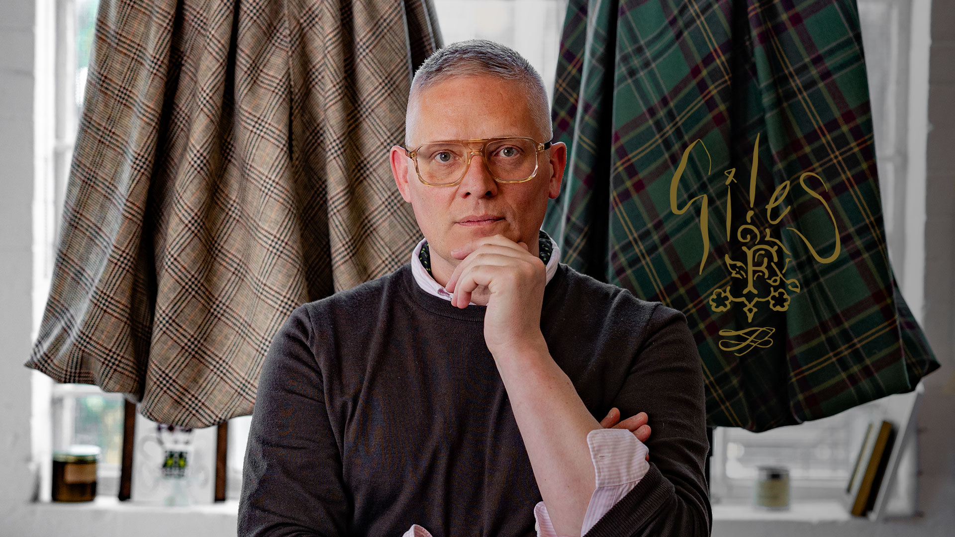 giles deacon poses in front of capes he has made for the fife arms