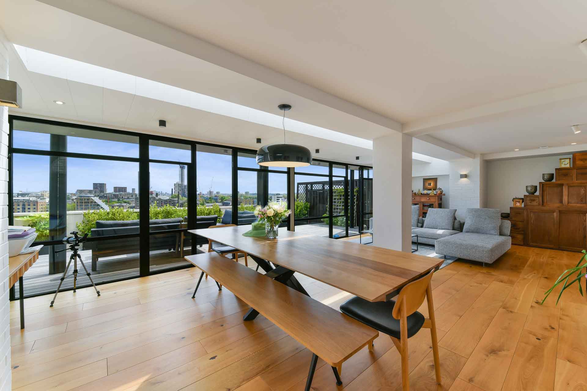 Penthouse with wooden flooring and dining table with bench seating