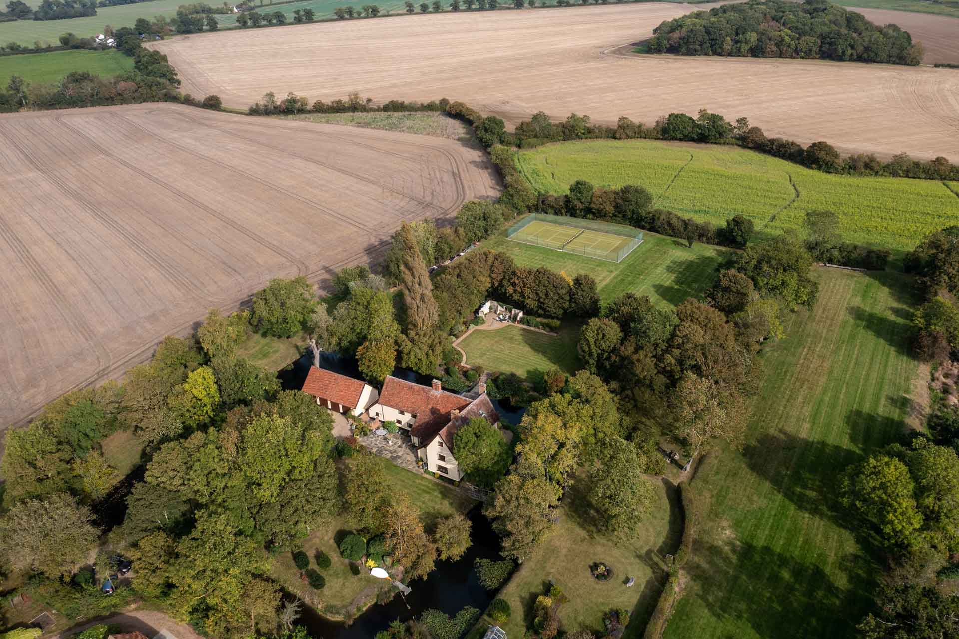 Aerial view of country home with extensive grounds and a tennis court