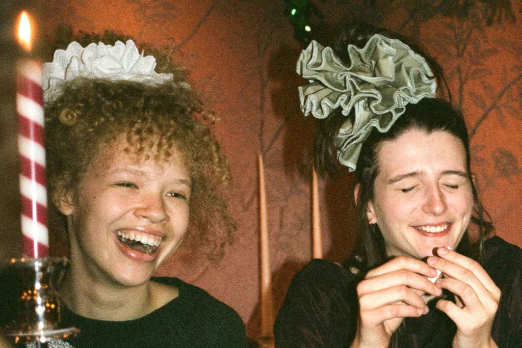 Two women wearing hair scrunchies at party