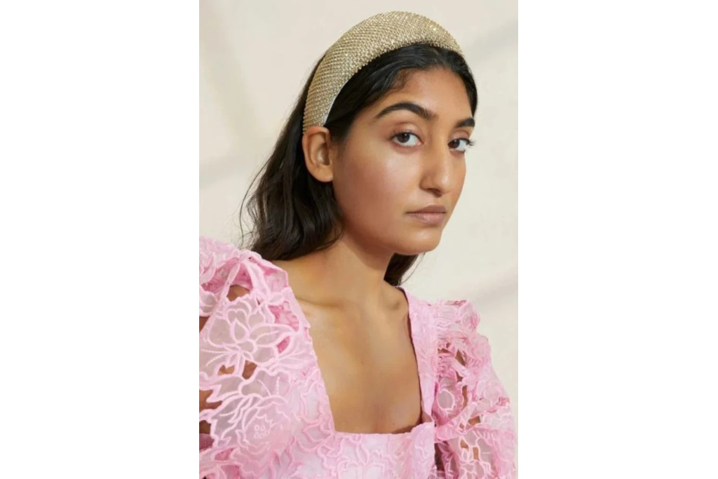 Woman in gold headband and pink top