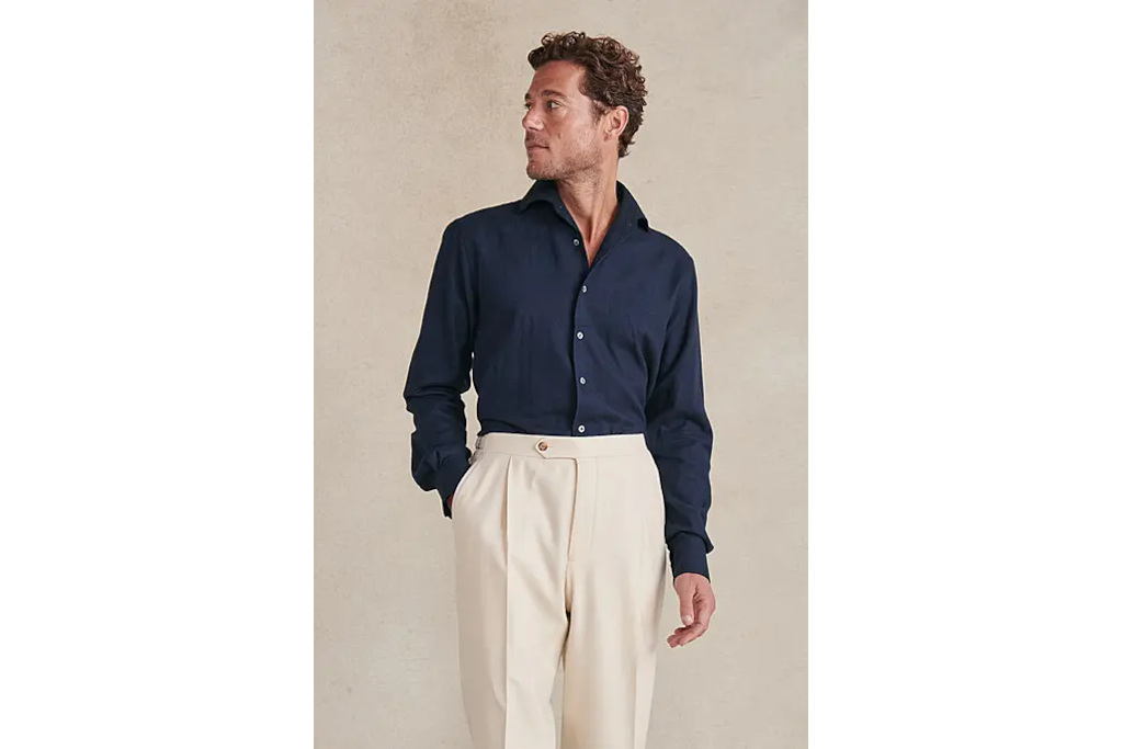 Man in navy shirt and cream trousers