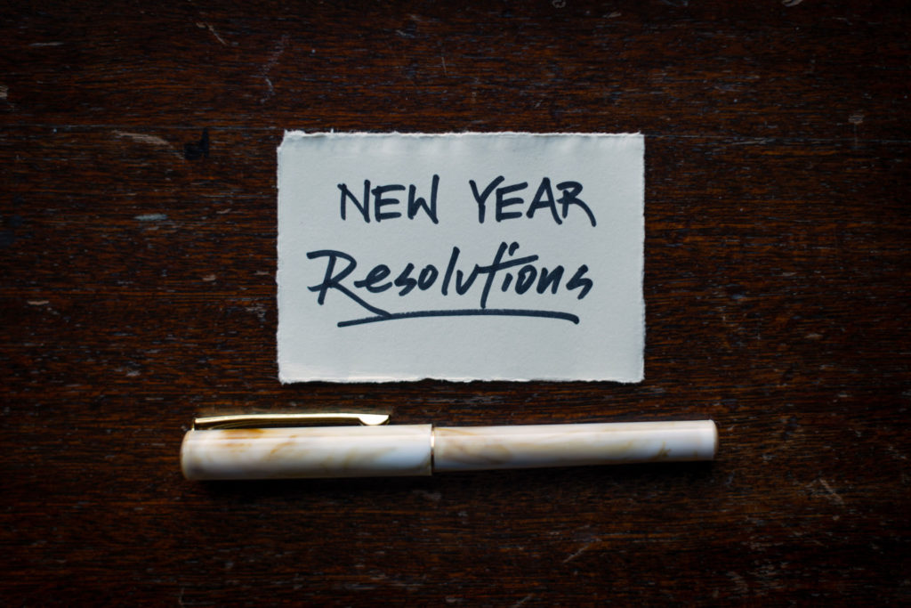 Post-it note reading 'New year resolution' with pen below