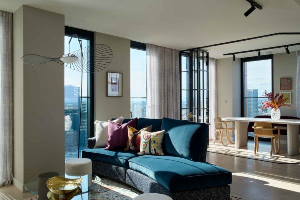 Living room with curved blue velvet sofa and curved dining table