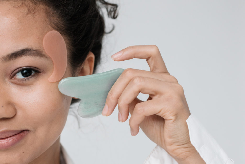 Woman using gua sha - skincare trends 2024