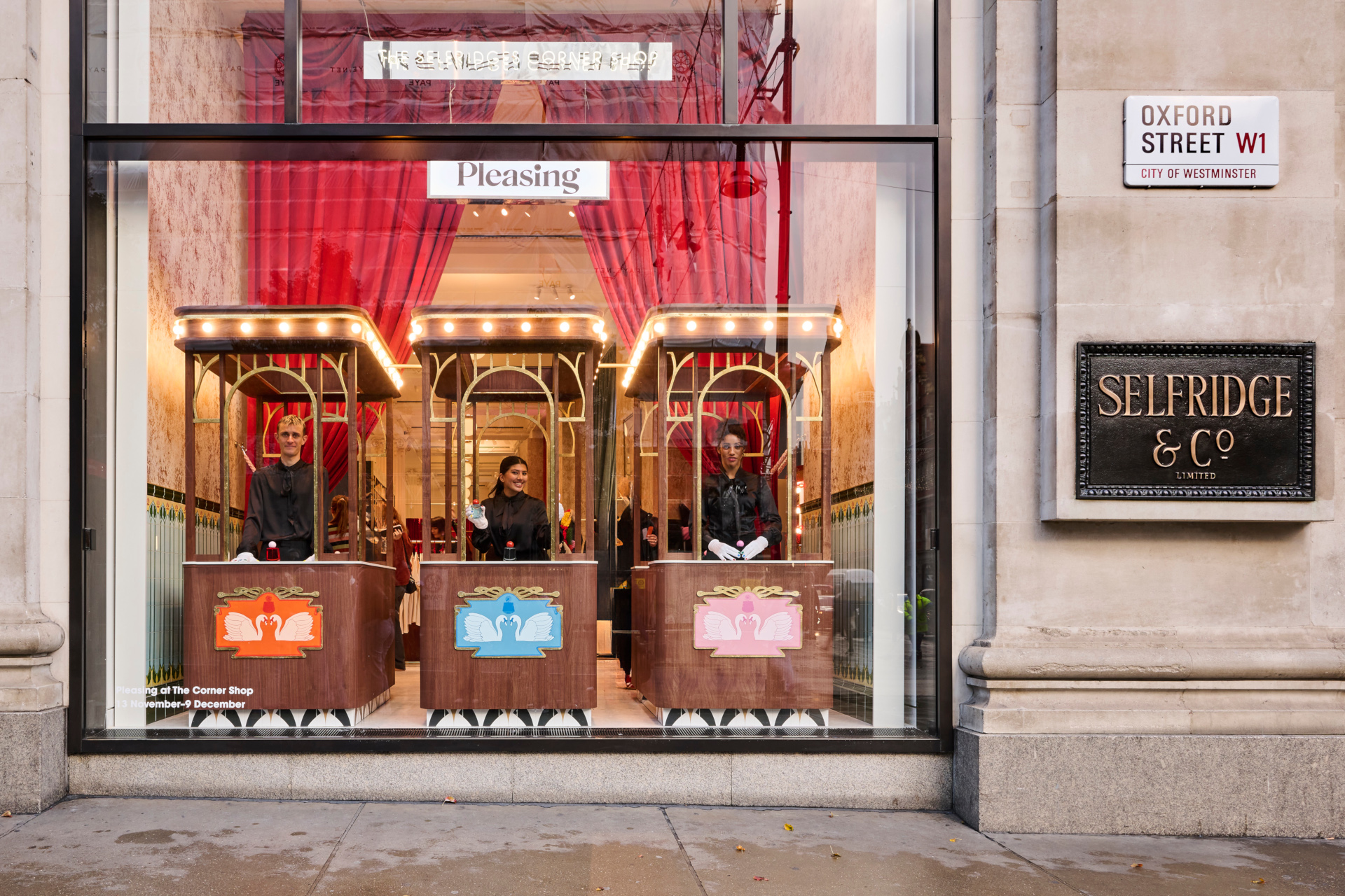 People in booths in Selfridges shop window