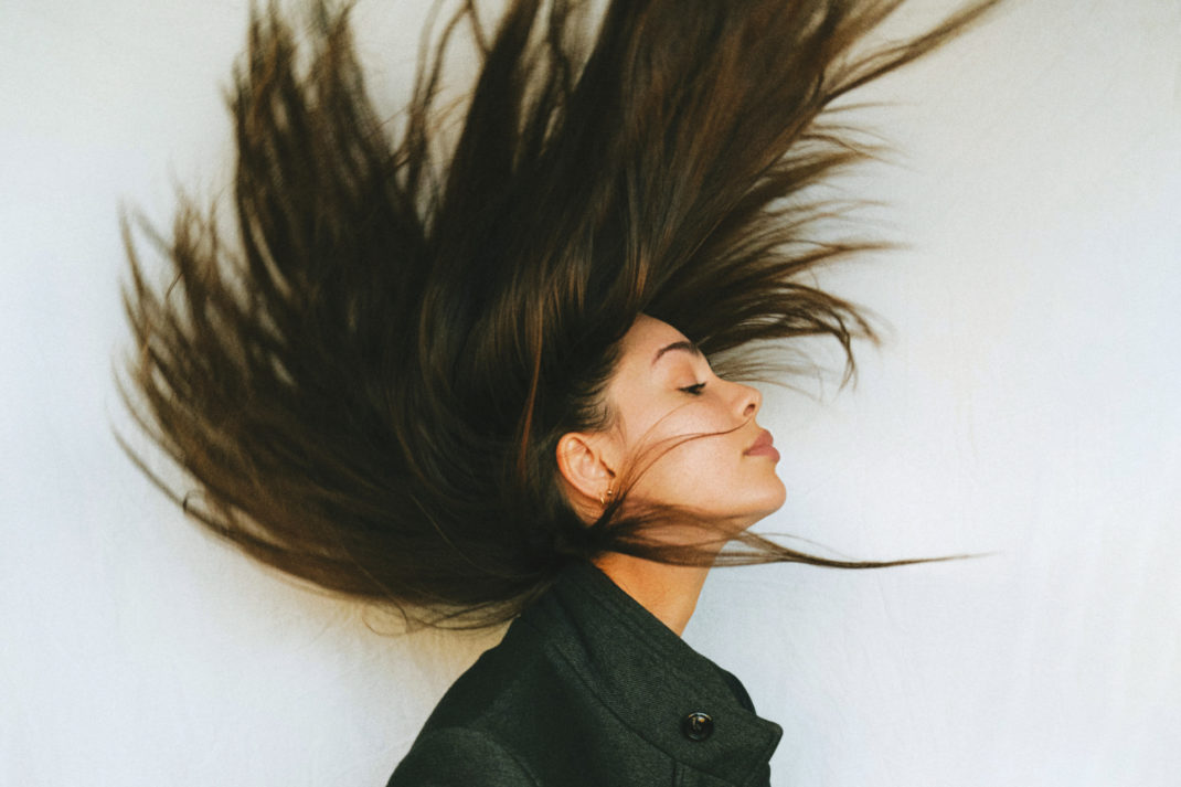 Woman throwing hair bakc