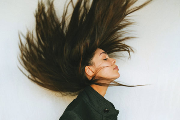 Woman throwing hair bakc