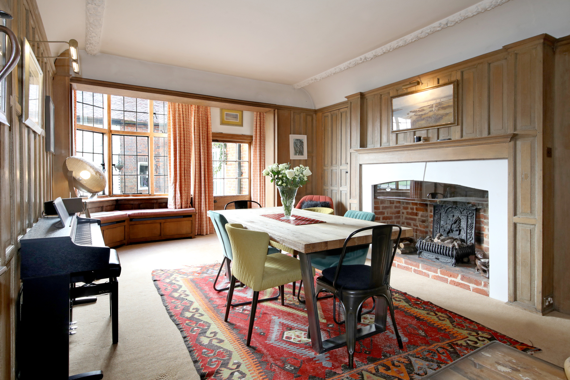 Wooden panelled dining room with red rug