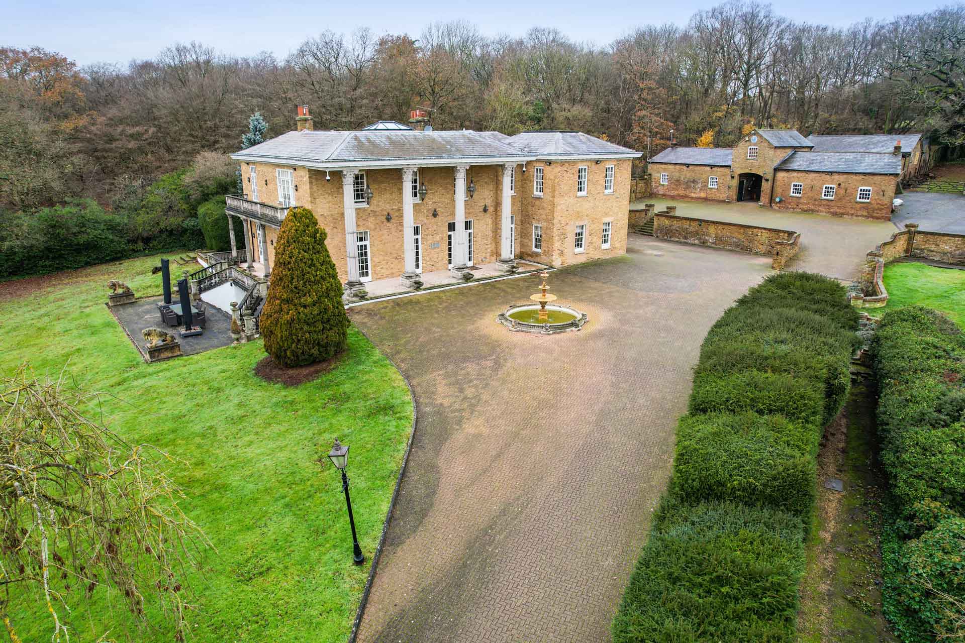 Aerial view of country manor with columns and sweeping driveway