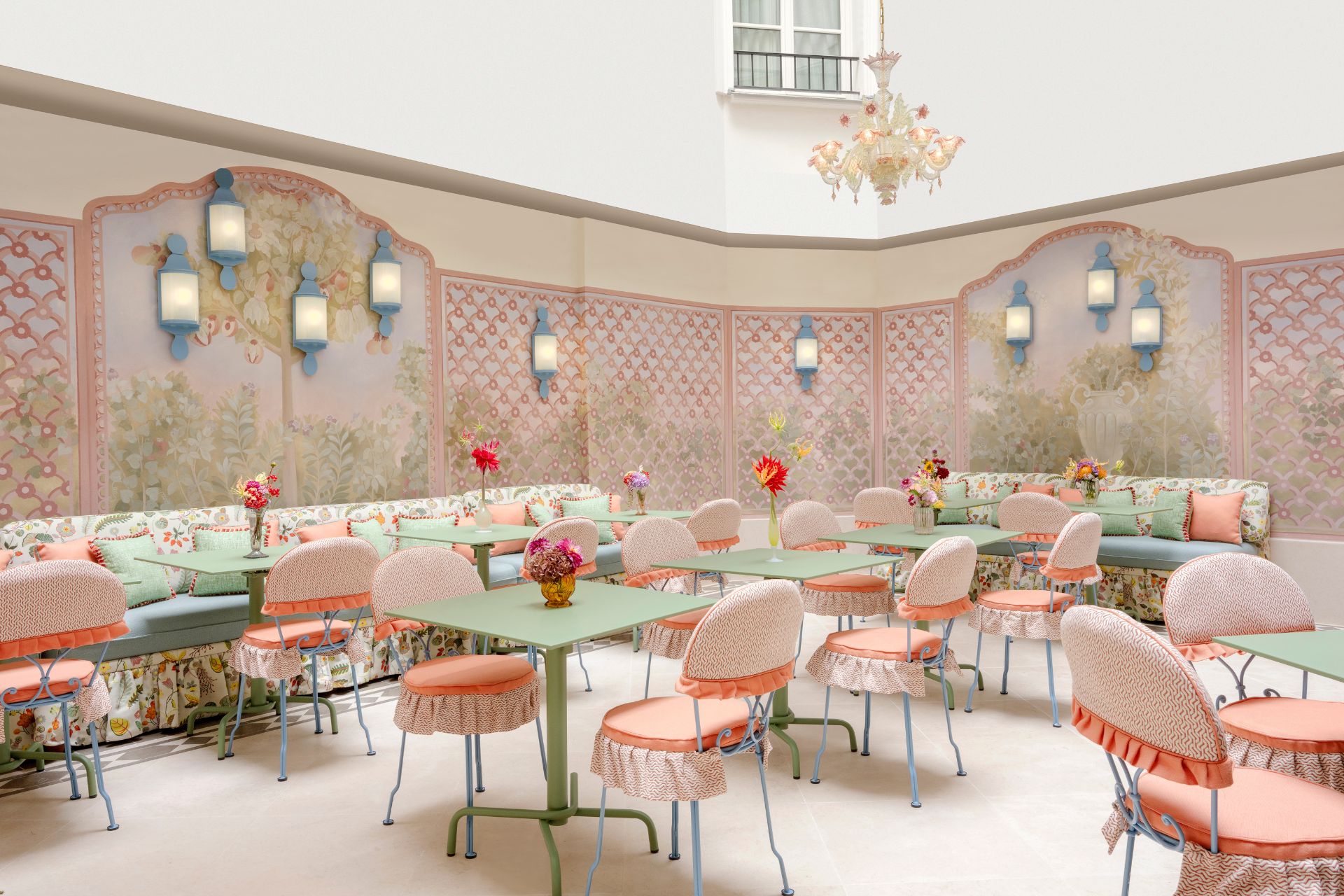 Hotel dining room with pale pink chairs, pale green tables and pink and white wallpaper