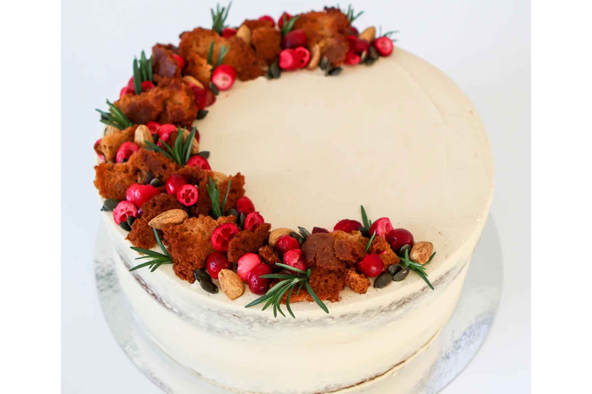 Sticky toffee celebration cake decorated with white buttercream and flowers