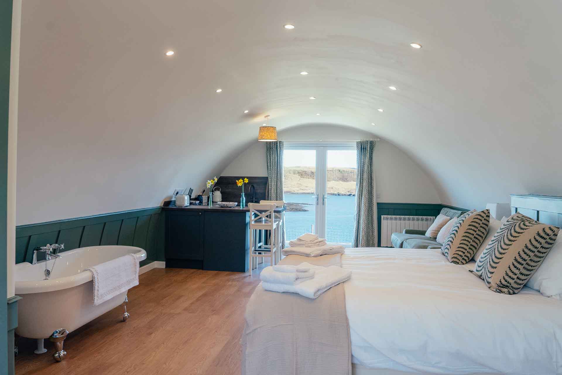 Cabin at WildLuing with a bed, roll top bath and view of the island