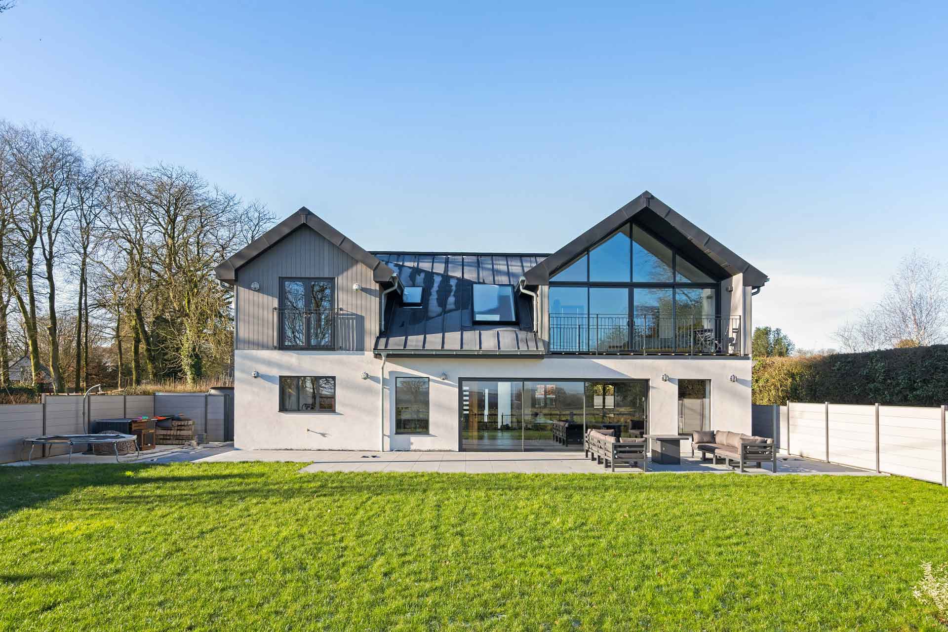 New-build home with floor-to-ceiling windows and large front lawn