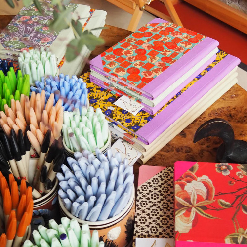 Colourful books on table with pens