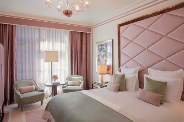 Pastel pink bedroom with mint green accents and satin headboard