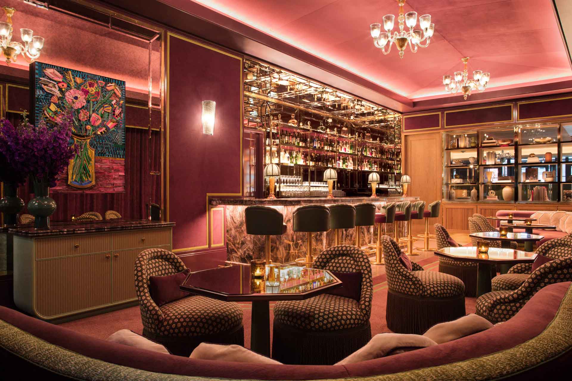 Bar with plum accents, velvet chairs and chandeliers